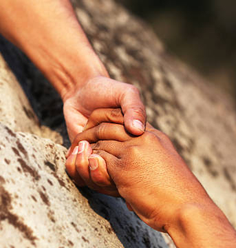 A handing to help their partner in mountains.